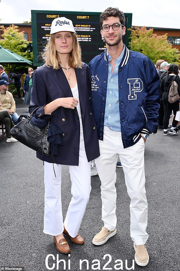 法国模特康斯坦斯·雅布隆斯基 (Constance Jablonski) 挽着她骑自行车的丈夫马蒂亚斯·丹多瓦 (Matthias Dandois) 的手臂抵达