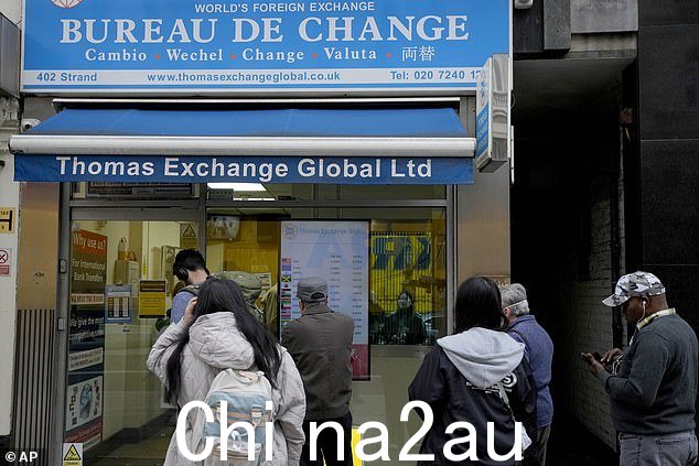 人们在伦敦外币兑换处排队(文件图片)。英国强劲的经济增长使人们对何时最终降息产生新的怀疑,英镑飙升