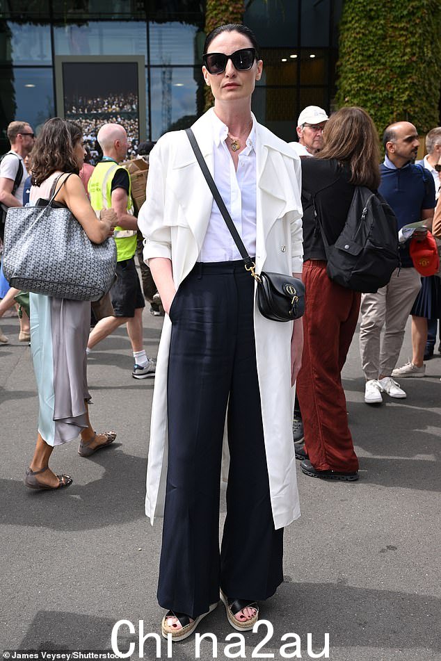 Erin O'Connor 穿着别致的白色风衣和衬衫,搭配黑色长裤