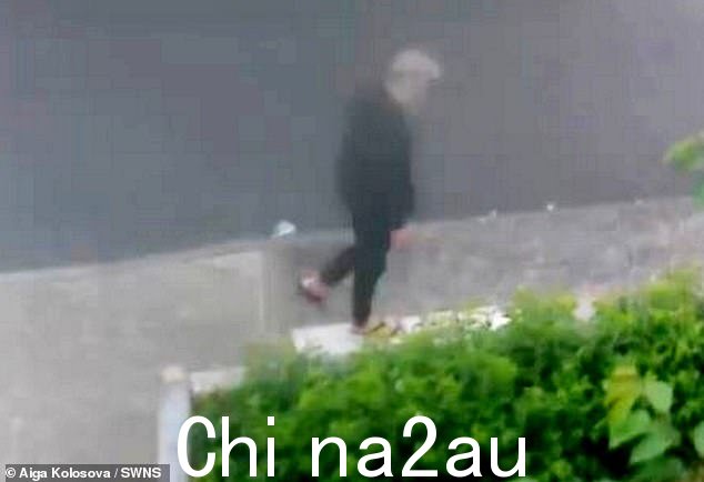 身穿黑色连帽衫、黑色紧身裤和配套的人字拖,金发罪犯走开,好像什么也没发生过