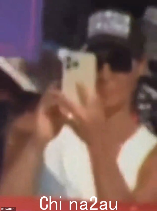 病毒视频显示,周六宾夕法尼亚州集会上枪声响起时,一名身份不明的女子 - 戴着墨镜、白衬衫和黑帽子 - 拿出手机” class=