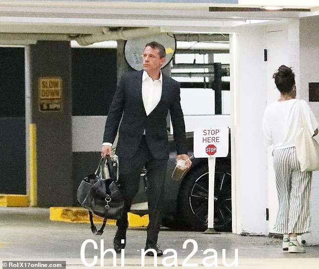 格温妮丝·帕特洛 (Gwyneth Paltrow) 的前男友拎着一个黑色行李袋,手里拿着一杯冰咖啡