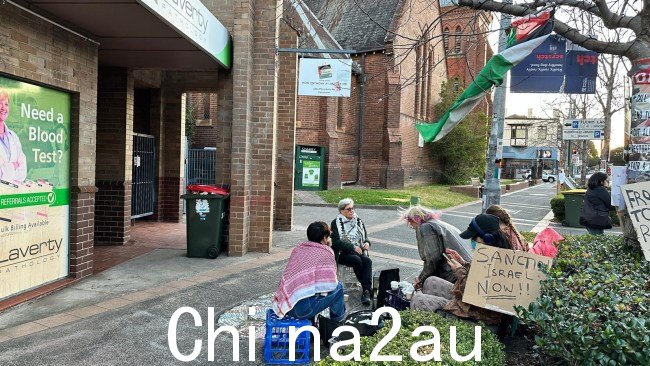 图像显示,少数活动人士坐在距离办公室稍远的地方,以避免限制出入。图片:《澳大利亚人报》size=