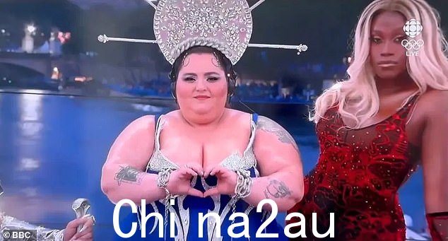 场景中央是一名戴着金色光环式皇冠的 DJ 设备前的女人,周围是几名变装皇后和数十名舞者和表演者