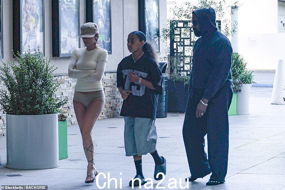 她在深棕色的头发上戴了一顶米色棒球帽,为她那奇异的无裤装扮增色不少