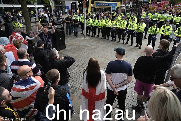 警察在参加反种族主义反抗议活动的人们(向右)和在皮卡迪利花园抗议的活动人士之间形成鸿沟