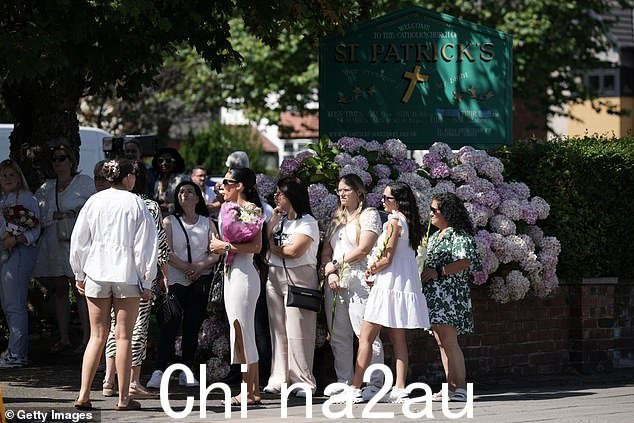 可以看到悲伤的人群手捧鲜花,并且大多穿着浅色衣服