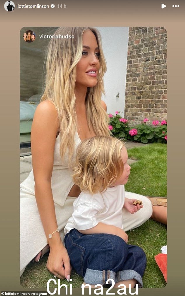Lottie 穿着一件奶油色背心,系着一朵花,搭配一条配套的奶油色拖地长裤,与她可爱的小男孩合影