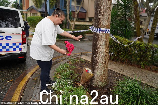心碎的社区成员在涉嫌谋杀的现场留下了鲜花
