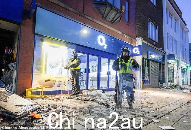 2024 年 8 月 3 日,防暴警察在约克郡赫尔一家受损的 O2 商店外守卫