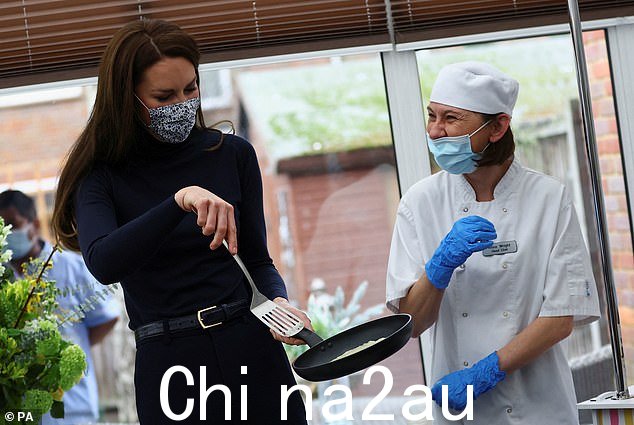戴着花卉口罩的凯特,在烹饪煎饼时与厨师一起欢笑