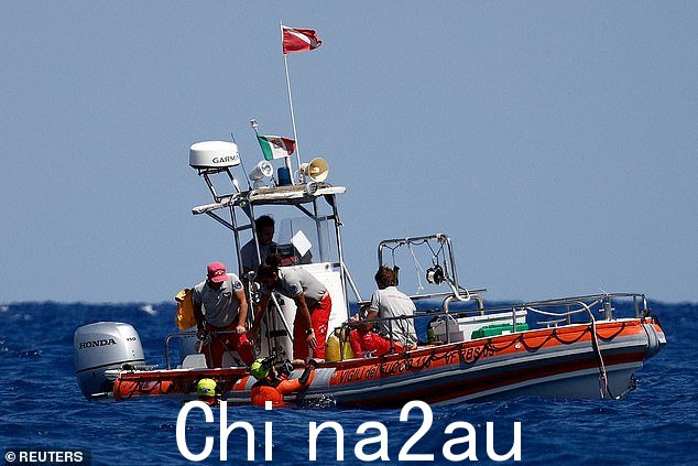 救援人员和潜水员今天在失事超级游艇上方的水面上进行操作