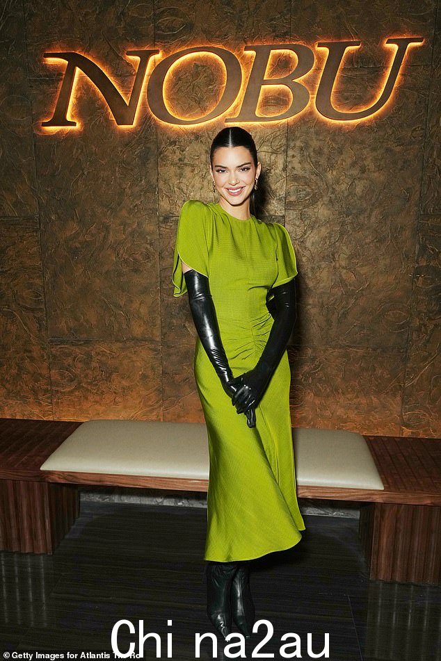 影响者 Kendall Jenner,28 岁,穿着“鹦鹉绿”版本的中长连衣裙