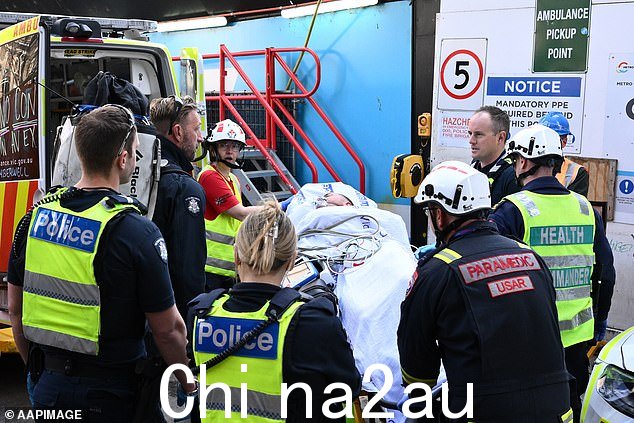 上午晚些时候,该男子被担架抬出建筑工地,送上等候的救护车,事件得到解决(如图所示)
