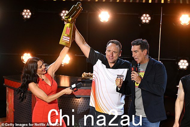 Nikki 和联合主持人 Rob Riggle(右)在获胜者 Joey Chestnut 获胜后与他合影