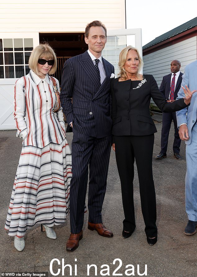 《Vogue》杂志编辑 Anna Wintour 穿着一件引人注目的铁锈红、蓝、白条纹衬衫式连衣裙,搭配她标志性的色调(图为汤姆和吉尔·拜登博士)