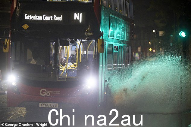 伦敦东南部格林威治遭遇暴雨和雷暴后,一辆巴士驶过部分被淹没的道路