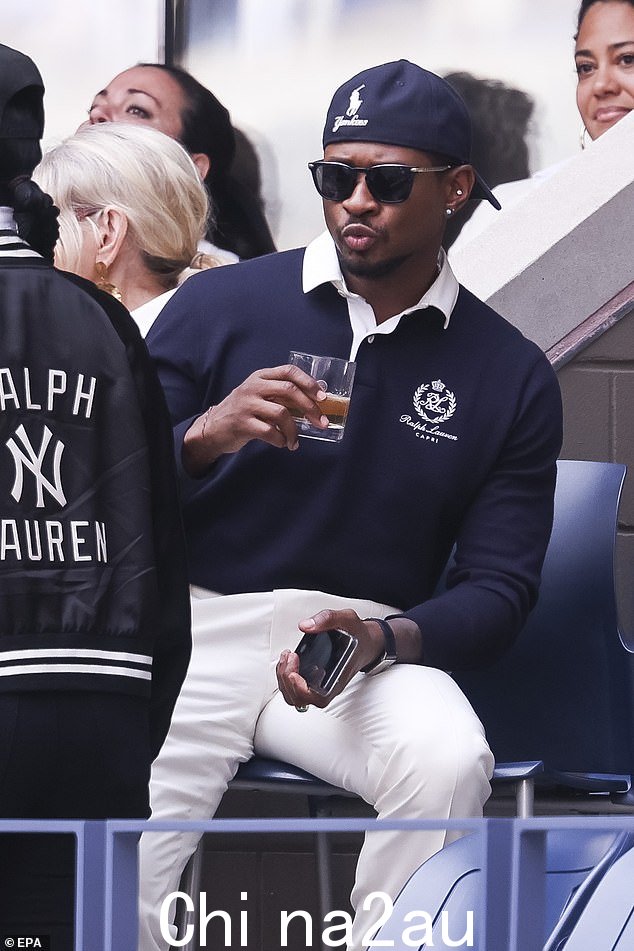 这位 R&B 音乐偶像身穿海军蓝色 Ralph Lauren Polo 衫,搭配白色长裤,头戴反戴棒球帽