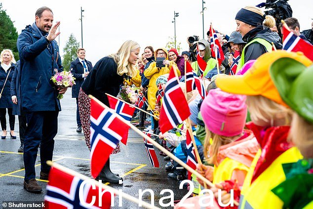 Mette-Marit 用一双黑色惠灵顿靴子和一些黑白相间的硫磺手套完成了她的服装,哈康王子也出现在