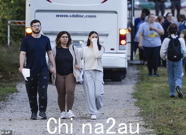 来自圣路易斯的萨默·希什梅(中)和佐仓·哈桑在与另一名男子一起走开抗议处决马塞勒斯·威廉姆斯的活动时,手牵手哭泣。密苏里州惩教署监狱