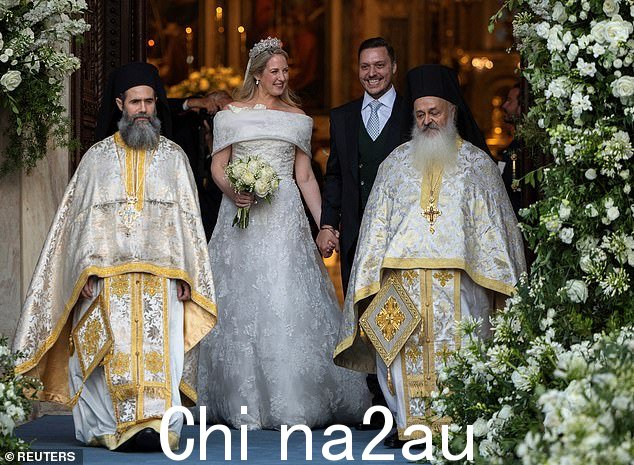 闪闪发光的新婚夫妇走在大教堂官员身后,准备迎接公众
