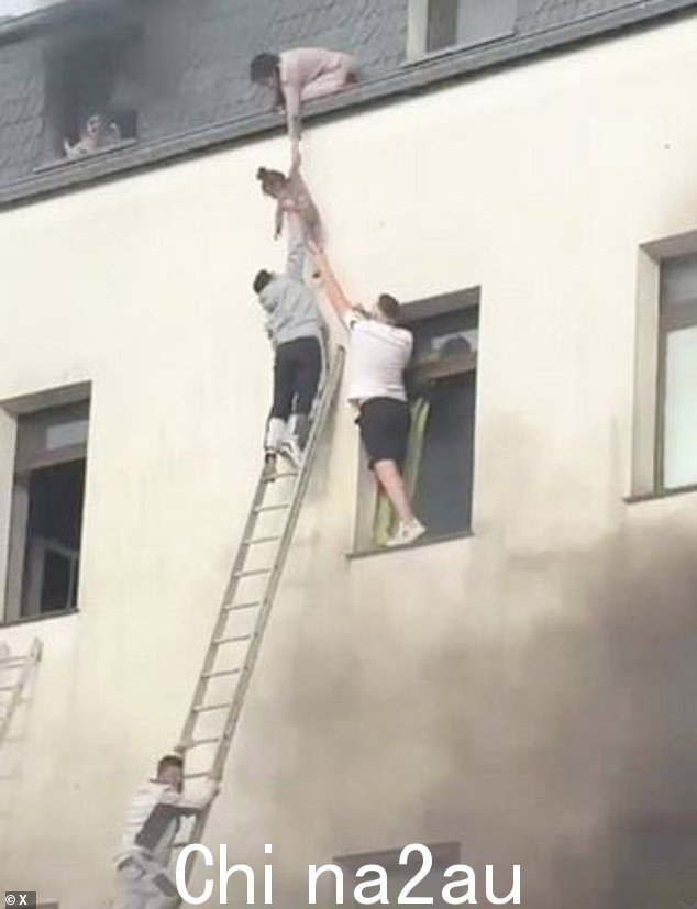 邻居试图用梯子爬上去帮助人们逃生,但梯子不够长,无法到达楼上,所以勇敢的居民齐心协力将孩子从屋顶降下来