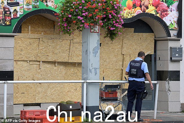 一名警察在埃森一家食品店前巡逻,一名男子将一辆货车撞向食品店