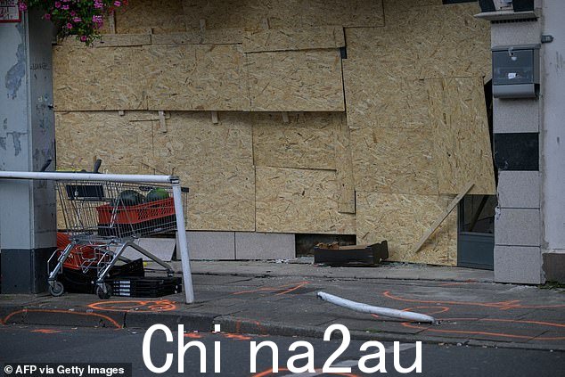 在德国西部埃森,可以看到一家食品店的窗户被木板封住,一名男子将一辆货车撞向其中