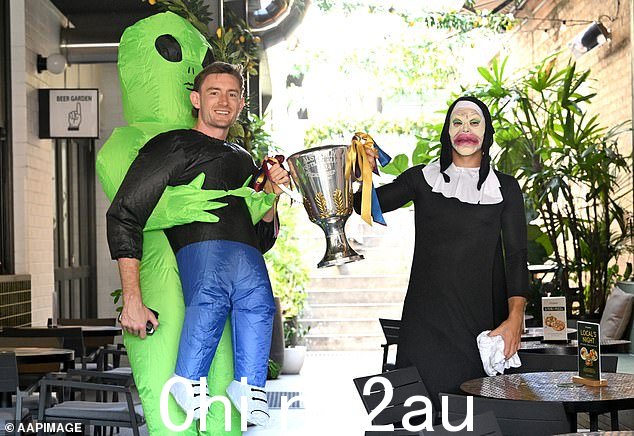 哈里斯·安德鲁斯(左)和卡姆·雷纳穿着古怪的服装带着 AFL 英超杯出现在酒吧