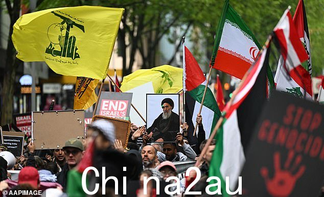 墨尔本抗议者高举镶框照片最近被杀的真主党老大哈桑·纳斯鲁拉(如图中)和真主党的黄色和绿色旗帜(如图左)