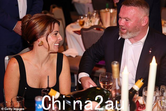 当他们坐在颁奖台上时,科琳在准备接受荣誉时深情地凝视着她的丈夫