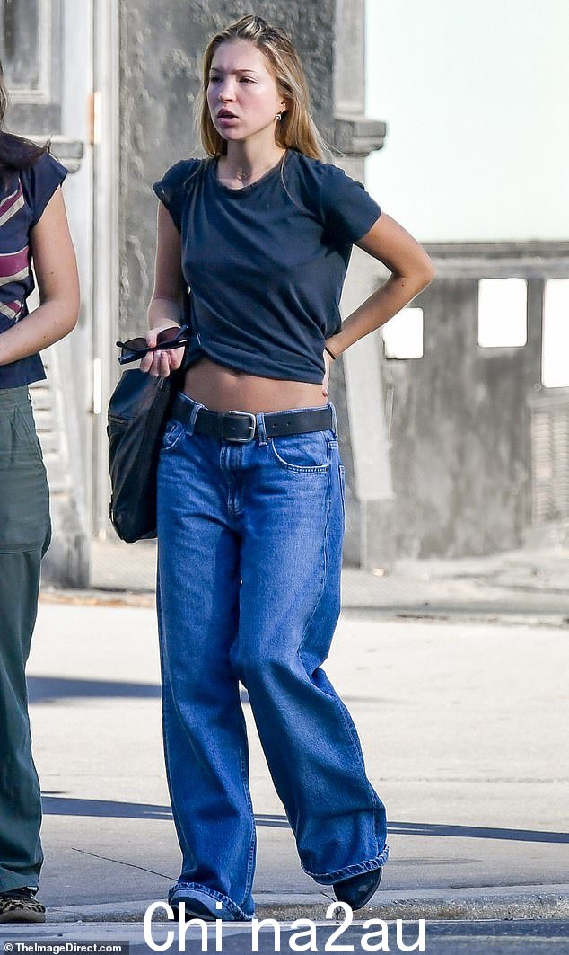 凯特·莫斯 (Kate Moss) 的模特女儿在出门时穿着海军蓝短款 T 恤和宽松牛仔裤,没有戴胸罩