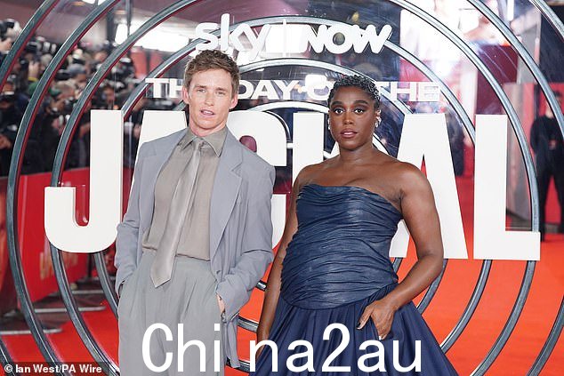 她在即将上映的英国连续剧中的搭档埃迪·雷德梅尼 (Eddie Redmayne) 也走上了地毯,穿着银灰色西装,看起来典型英俊