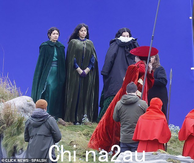 Charli 在拍摄间隙将自己包裹在温暖的蓬松外套中,确保保持温暖