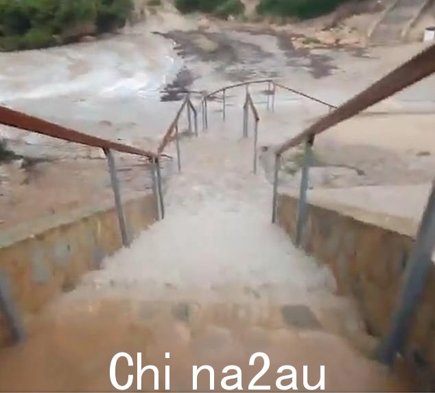 马略卡岛一个小镇的道路被洪水淹没,水从楼梯上流下来