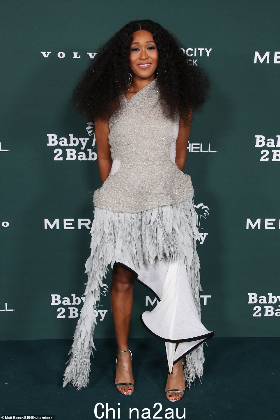 Naomi Osaka 展示了她前卫别致和有趣的风格,她塑造了一个别致的造型闪亮针织连衣裙,不对称上衣搭配波浪裙内衬羽毛