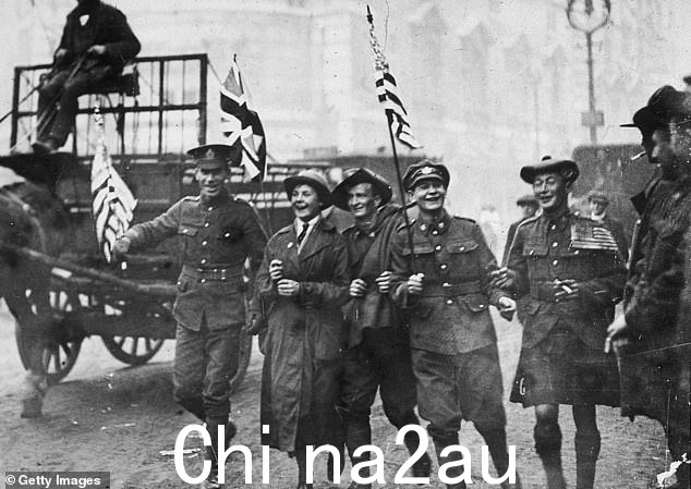 1918 年 11 月 11 日停战日,一群士兵沿着海滩奔跑,其中包括一名苏格兰人、一名澳大利亚人和一名女子陆军辅助部队成员