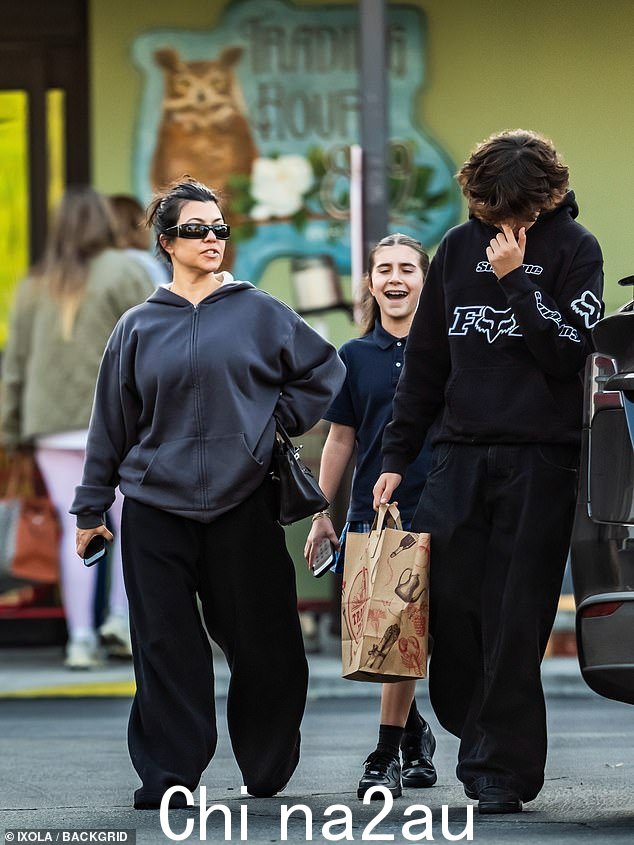 考特尼 (Kourtney) 休闲装穿着黑色运动衫和炭色拉链连帽衫,拎着 Hermes Birkin 包