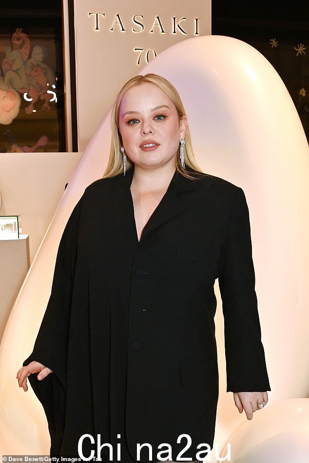 Derry Girls 明星,37 岁,身着带有不对称袖子和流苏细节的斗篷黑色迷你连衣裙,搭配透明紧身裤和高跟鞋,尽显美感