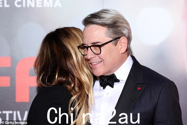 他们在红地毯上展现出可爱的样子,莎拉停下来在她丈夫的耳边低声说了些什么