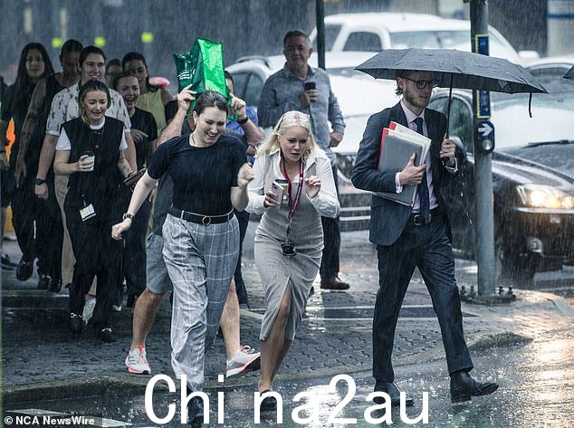 Mr How 先生补充说,到周五晚上,全国大部分地区的月降雨量可能会达到甚至超过 11 月的平均降雨量(如图,布里斯班 CBD 工作人员躲避降雨)