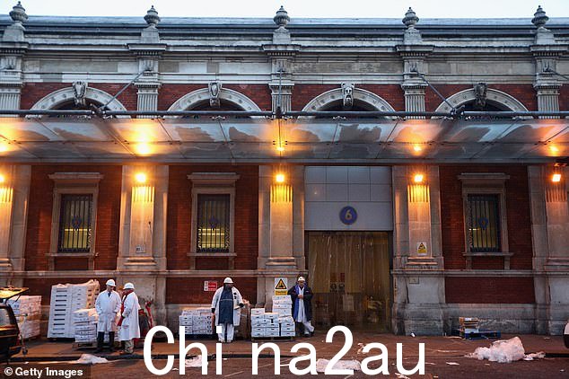 屠夫准备运送肉类2013 年 3 月 14 日在史密斯菲尔德市场出售,该市场正式命名为“伦敦中央市场”。该市场的维多利亚式建筑由城市建筑师霍勒斯·琼斯爵士设计,于 1860 年代竣工” class=