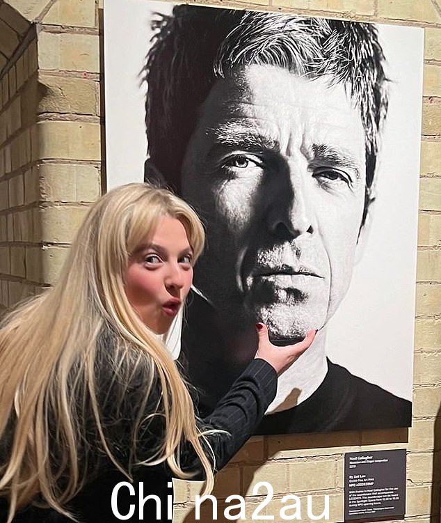 诺埃尔·加拉格尔 (Noel Gallagher) 的女儿阿奈斯 (Anais) 在国家肖像画廊的佐伊·劳 (Zoe Law) 传奇展览上,在父亲的照片旁边摆出俏皮的姿势
