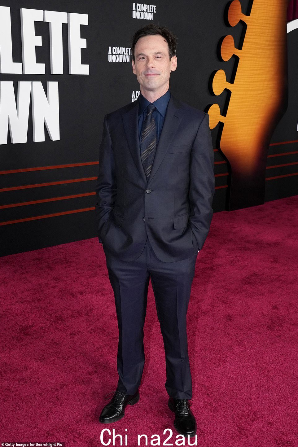 Scoot McNairy 选择了一套更为保守的海军蓝西装,搭配了一件撞色的蓝色衬衫和一条海军蓝条纹领带。他在《A Complete Unknown》中饰演传奇民谣歌手 Woody Guthrie,这是对 Dylan 的早期影响